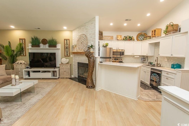 108 Pipers Ln Unit 108, Myrtle Beach, SC 29575 - kitchen with a fireplace, open floor plan, stainless steel appliances, light countertops, and white cabinetry