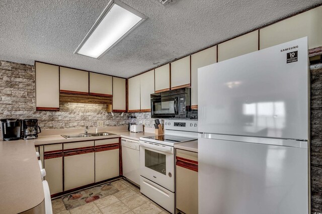 912 N Waccamaw Dr Unit 904, Garden City Beach, SC 29576 - kitchen with white appliances, a sink, a textured ceiling, light countertops, and cream cabinets