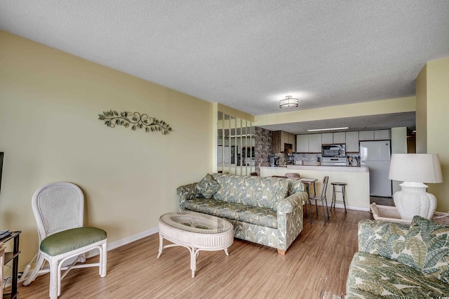 912 N Waccamaw Dr Unit 904, Garden City Beach, SC 29576 - living room with wood finished floors, a textured ceiling, and baseboards
