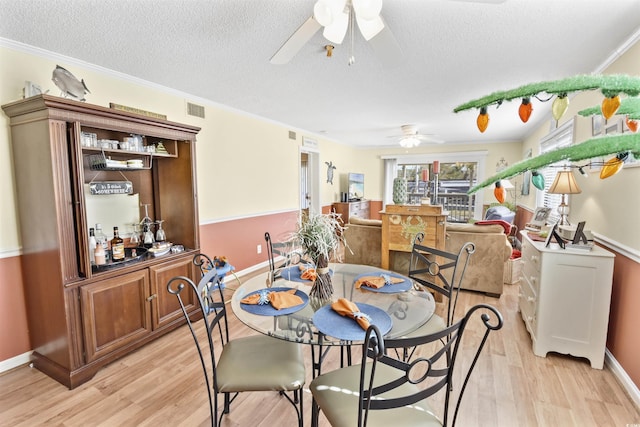 4350 Intercoastal Dr Unit 1101, Little River, SC 29566 - dining space with ceiling fan, light wood finished floors, a textured ceiling, baseboards, and crown molding