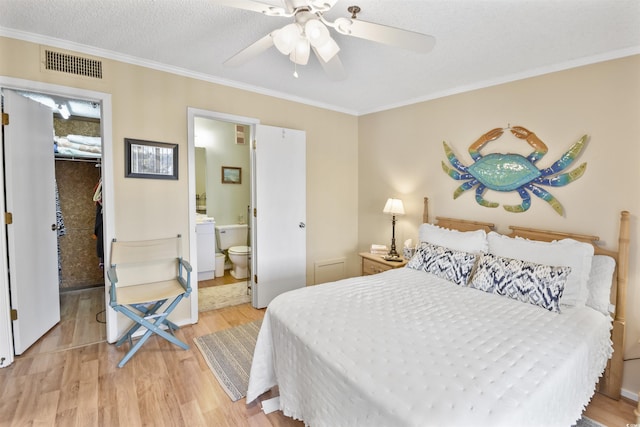 4350 Intercoastal Dr Unit 1101, Little River, SC 29566 - bedroom with a walk in closet, light wood-style flooring, ornamental molding, a closet, and ensuite bathroom