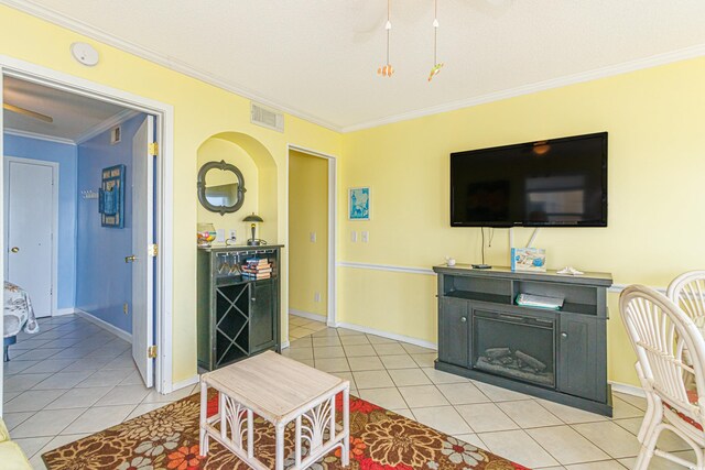 4525 S Ocean Blvd Unit 406, North Myrtle Beach, SC 29582 - living area featuring light tile patterned floors, crown molding, a ceiling fan, baseboards, and arched walkways