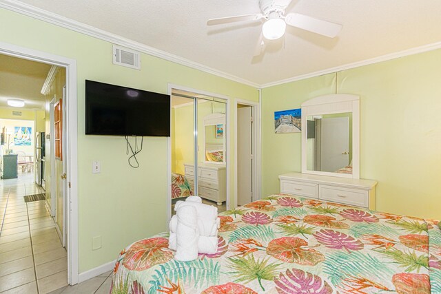 4525 S Ocean Blvd Unit 406, North Myrtle Beach, SC 29582 - bedroom featuring light tile patterned floors, crown molding, freestanding refrigerator, a closet, and a ceiling fan
