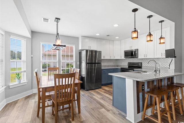 620 Seth Ln, Longs, SC 29568 - kitchen featuring stainless steel appliances, a sink, a peninsula, decorative backsplash, and white cabinetry