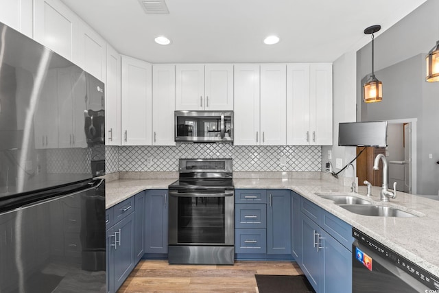 620 Seth Ln, Longs, SC 29568 - kitchen featuring stainless steel appliances, blue cabinetry, a sink, white cabinetry, and tasteful backsplash