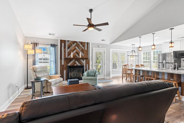 620 Seth Ln, Longs, SC 29568 - living area featuring a ceiling fan, a large fireplace, light wood-style flooring, baseboards, and lofted ceiling