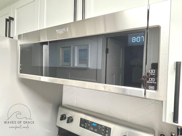 161 Seawatch Dr Unit 710, Myrtle Beach, SC 29572 - kitchen view of tasteful backsplash, stainless steel microwave, stove, and light countertops