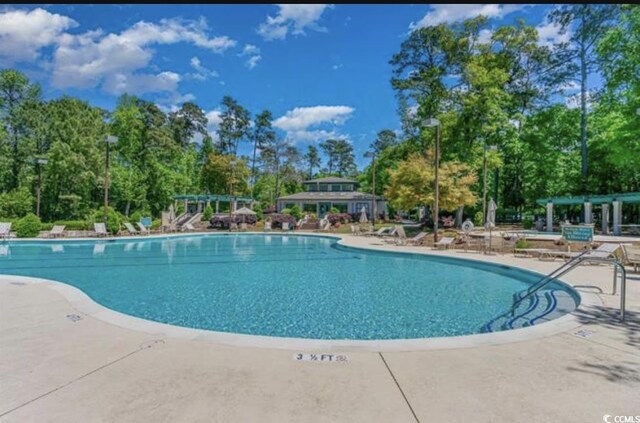 1221 Tidewater Dr Unit 122, North Myrtle Beach, SC 29582 - community pool featuring a pergola, a patio area, and view of wooded area