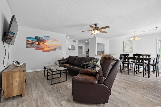 800 9th Ave S Unit E-4, North Myrtle Beach, SC 29582 - living room featuring a textured ceiling, wood finished floors, ceiling fan, and a chandelier