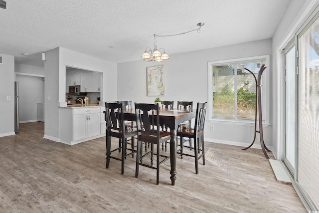 800 9th Ave S Unit E-4, North Myrtle Beach, SC 29582 - dining area featuring a textured ceiling, a chandelier, and light wood finished floors