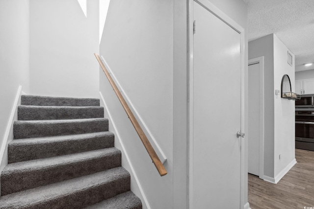 800 9th Ave S Unit E-4, North Myrtle Beach, SC 29582 - stairway with wood finished floors and a textured ceiling