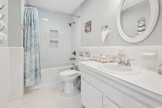 800 9th Ave S Unit E-4, North Myrtle Beach, SC 29582 - bathroom featuring vanity, shower / bath combo with shower curtain, tile walls, and a wainscoted wall