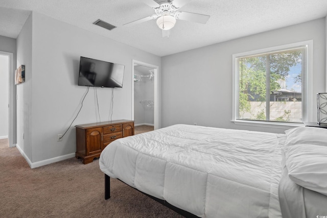 800 9th Ave S Unit E-4, North Myrtle Beach, SC 29582 - bedroom with a textured ceiling, light carpet, a spacious closet, and ceiling fan
