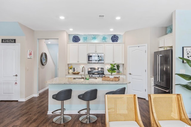 2504 Heritage Loop Unit 2504, Myrtle Beach, SC 29577 - kitchen featuring stainless steel appliances, a sink, white cabinetry, dark wood finished floors, and an island with sink