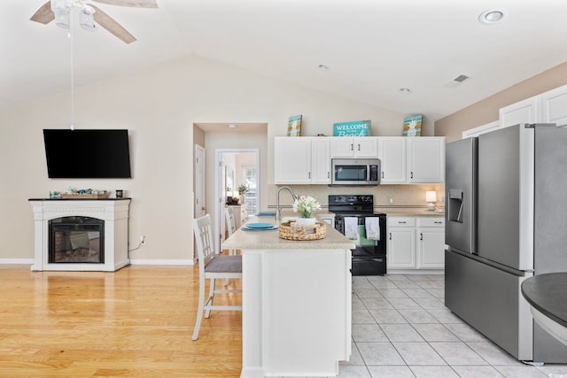 6681 Wisteria Dr, Myrtle Beach, SC 29588 - kitchen featuring appliances with stainless steel finishes, white cabinetry, lofted ceiling, light countertops, and recessed lighting