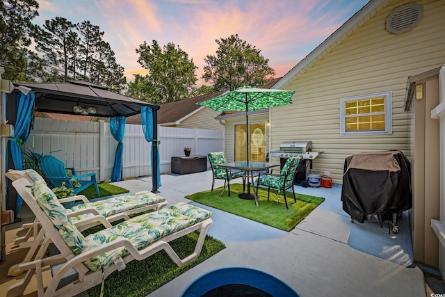 6681 Wisteria Dr, Myrtle Beach, SC 29588 - patio terrace at dusk with a gazebo, grilling area, a fenced backyard, and a patio area