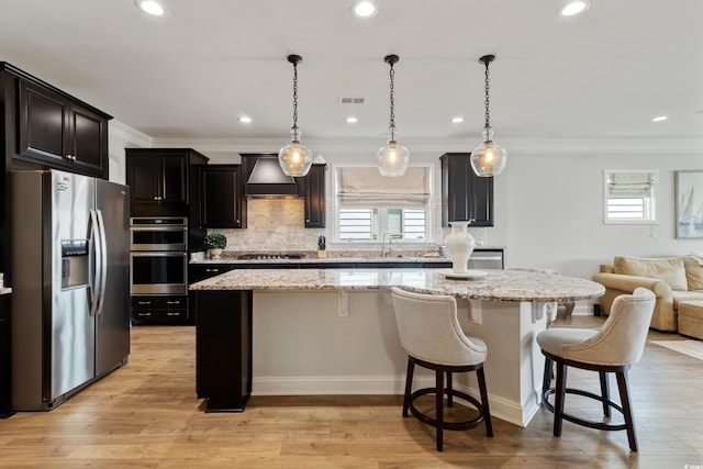 6378 Torino Ln, Myrtle Beach, SC 29572 - kitchen with appliances with stainless steel finishes, custom range hood, a center island, open floor plan, and decorative backsplash