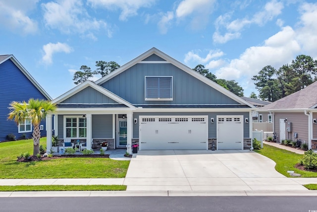 1352 Jolly Roger Dr, North Myrtle Beach, SC 29582 - craftsman house with a porch, driveway, board and batten siding, and stone siding