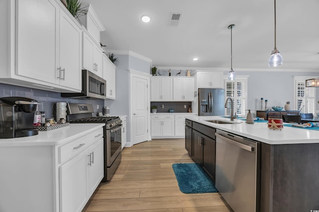 1352 Jolly Roger Dr, North Myrtle Beach, SC 29582 - kitchen with appliances with stainless steel finishes, crown molding, light countertops, a sink, and white cabinets