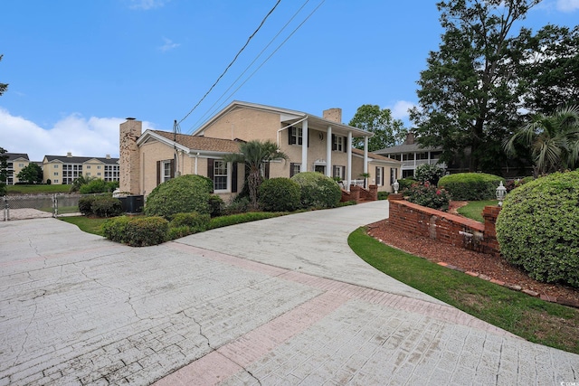 328 Waterside Dr, Myrtle Beach, SC 29577 - greek revival inspired property with a chimney, curved driveway, and central AC unit