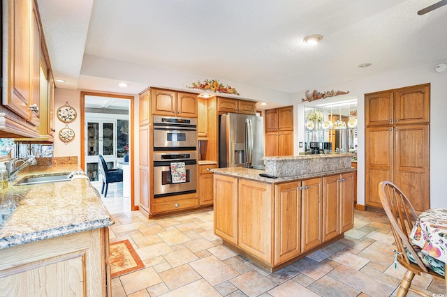 328 Waterside Dr, Myrtle Beach, SC 29577 - kitchen with appliances with stainless steel finishes, a sink, light stone countertops, a kitchen island, and light stone finish floors