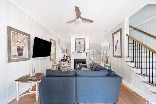 70 Beachwalker Ct, Georgetown, SC 29440 - living room with wood finished floors, a ceiling fan, a fireplace, stairs, and baseboards