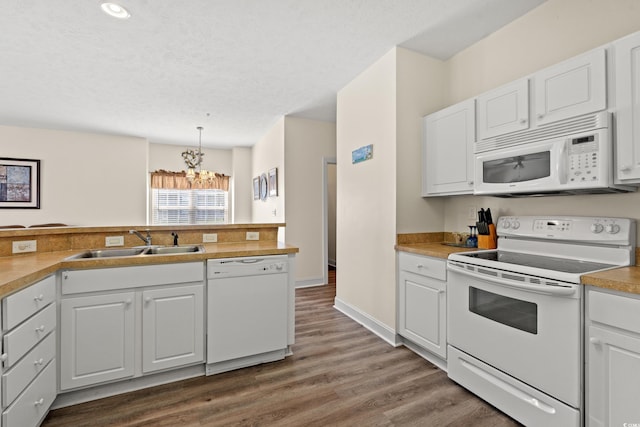 6000 Windsor Green Way Unit 104, Myrtle Beach, SC 29579 - kitchen featuring white appliances, dark wood-style floors, a chandelier, white cabinets, and light countertops