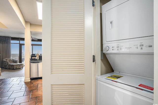 100 N Beach Blvd Unit 710, North Myrtle Beach, SC 29582 - laundry room featuring stacked washer / dryer and stone tile floors