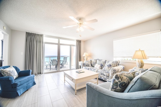 1903 S Ocean Blvd Unit 1110, North Myrtle Beach, SC 29582 - living room featuring a textured ceiling, a ceiling fan, and a wall of windows