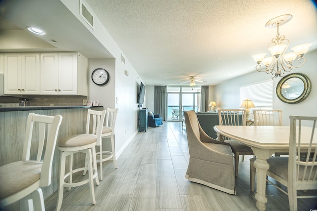 1903 S Ocean Blvd Unit 1110, North Myrtle Beach, SC 29582 - dining room with ceiling fan, baseboards, a chandelier, and a textured ceiling