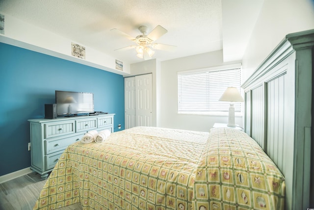 1903 S Ocean Blvd Unit 1110, North Myrtle Beach, SC 29582 - bedroom featuring wood finished floors, a ceiling fan, baseboards, a closet, and a textured ceiling