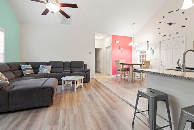 4331 Grande Harbour Blvd, Little River, SC 29566 - living room featuring ceiling fan, high vaulted ceiling, light wood finished floors, and a chandelier