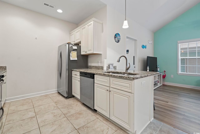 4331 Grande Harbour Blvd, Little River, SC 29566 - kitchen featuring appliances with stainless steel finishes, vaulted ceiling, a peninsula, light stone countertops, and decorative light fixtures