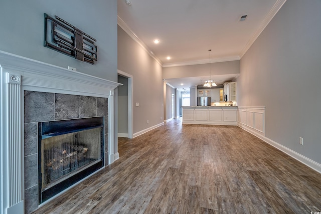 648 Sunnyside Dr Unit 102, Murrells Inlet, SC 29576 - unfurnished living room with wood finished floors, a fireplace, crown molding, a chandelier, and baseboards