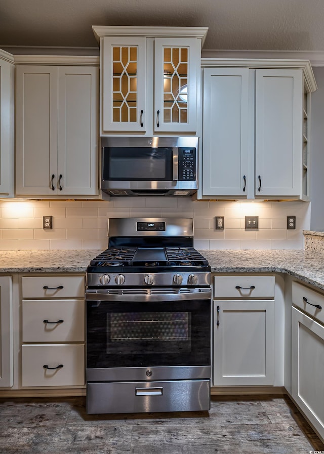 648 Sunnyside Dr Unit 102, Murrells Inlet, SC 29576 - kitchen featuring stainless steel appliances, decorative backsplash, dark wood-type flooring, and light stone counters