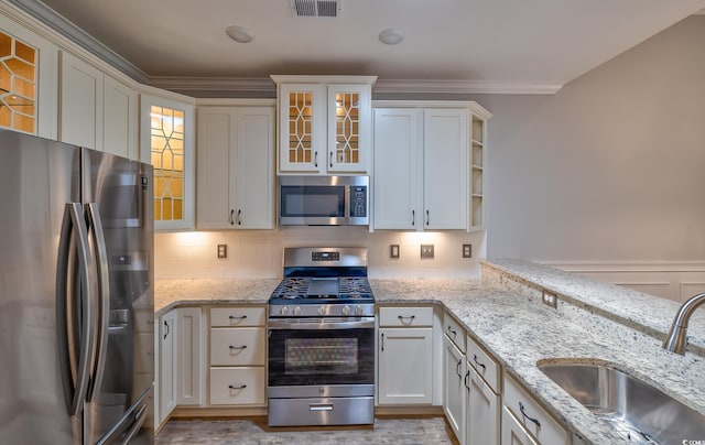 648 Sunnyside Dr Unit 102, Murrells Inlet, SC 29576 - kitchen with stainless steel appliances, a sink, backsplash, glass insert cabinets, and light stone countertops