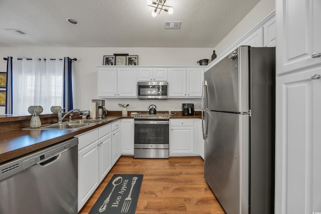 6309 Sweetwater Blvd ., Unit Murrells Inlet, SC 29576 - kitchen featuring appliances with stainless steel finishes, dark countertops, white cabinets, and a textured ceiling