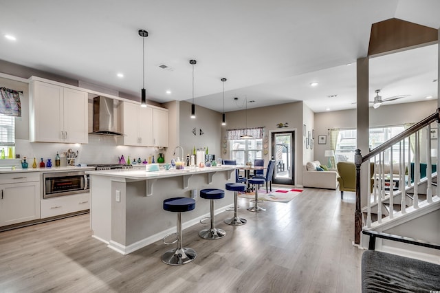 5013 Sassari St, Myrtle Beach, SC 29579 - kitchen with wall chimney exhaust hood, appliances with stainless steel finishes, light wood-style flooring, light countertops, and recessed lighting