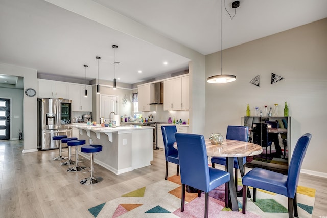 5013 Sassari St, Myrtle Beach, SC 29579 - kitchen featuring appliances with stainless steel finishes, light wood-style floors, a center island with sink, white cabinets, and recessed lighting