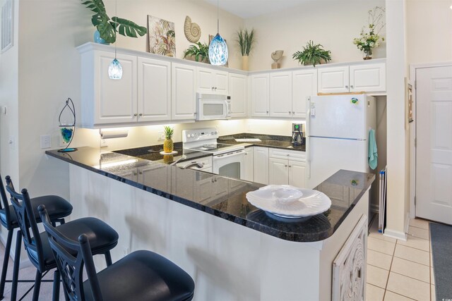 601 Hillside Dr N Unit 1931, North Myrtle Beach, SC 29582 - kitchen with white appliances, a kitchen bar, a peninsula, and white cabinets