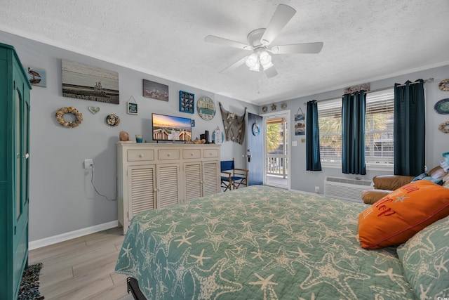 5909 N Ocean Blvd Unit 18, North Myrtle Beach, SC 29582 - bedroom with a textured ceiling, an AC wall unit, baseboards, access to outside, and a ceiling fan