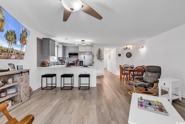 1870 Auburn Dr Unit 22A, Surfside Beach, SC 29575 - kitchen with stainless steel appliances, gray cabinetry, a peninsula, a ceiling fan, and light wood finished floors