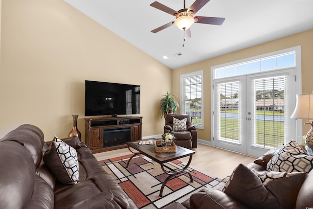 1149 6th Ave S, North Myrtle Beach, SC 29582 - living area featuring light wood-style floors, a fireplace, vaulted ceiling, ceiling fan, and french doors
