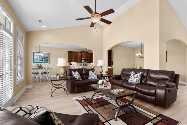 1149 6th Ave S, North Myrtle Beach, SC 29582 - living room with arched walkways, a chandelier, high vaulted ceiling, a ceiling fan, and light wood-style floors
