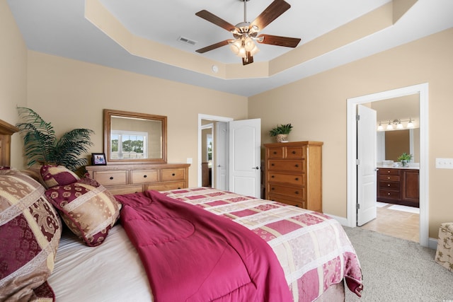 1149 6th Ave S, North Myrtle Beach, SC 29582 - bedroom featuring light carpet, a tray ceiling, connected bathroom, and ceiling fan