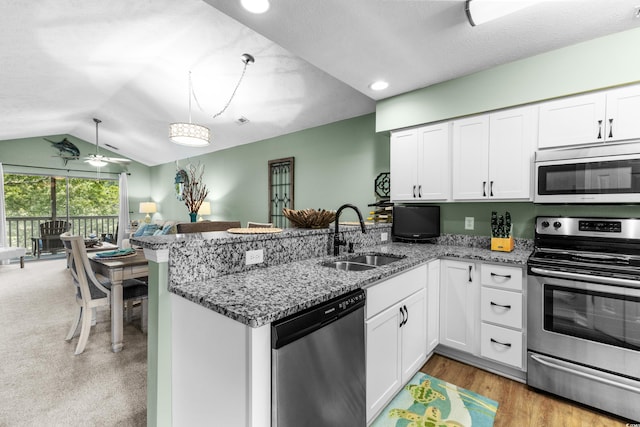 117 Pinehurst Ln Unit 5-J, Pawleys Island, SC 29585 - kitchen featuring stainless steel appliances, a sink, a peninsula, vaulted ceiling, and white cabinetry