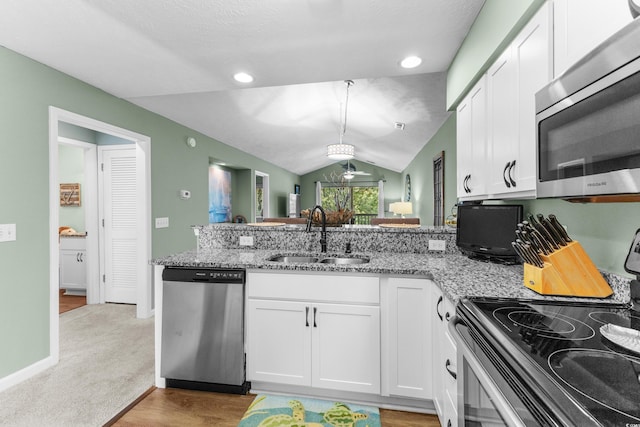 117 Pinehurst Ln Unit 5-J, Pawleys Island, SC 29585 - kitchen with stainless steel appliances, a sink, lofted ceiling, white cabinets, and light stone countertops