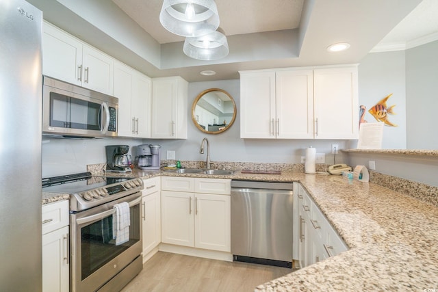 8560 Queensway Blvd Unit 106, Myrtle Beach, SC 29572 - kitchen featuring stainless steel appliances, a sink, light wood-style flooring, white cabinetry, and light stone counters