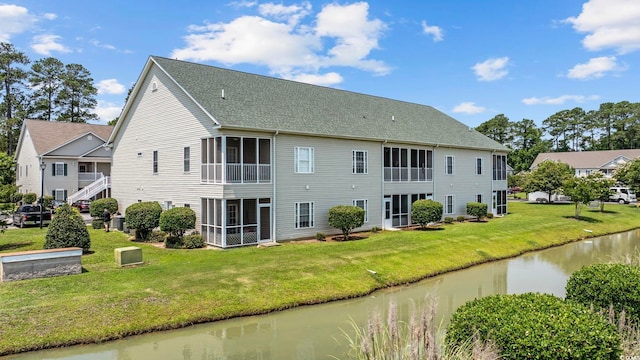 155 Lazy Willow Ln Unit 103, Myrtle Beach, SC 29572 - rear view of property featuring a sunroom, a water view, a lawn, and roof with shingles