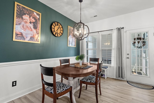 136 Southbury Dr, Myrtle Beach, SC 29588 - dining area with a chandelier, light wood-type flooring, and a wainscoted wall